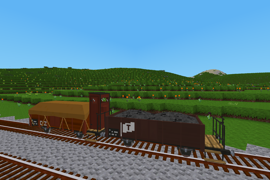 Two loaded European small open wagons, one with a brakeman's hut, wait to be picked up.
